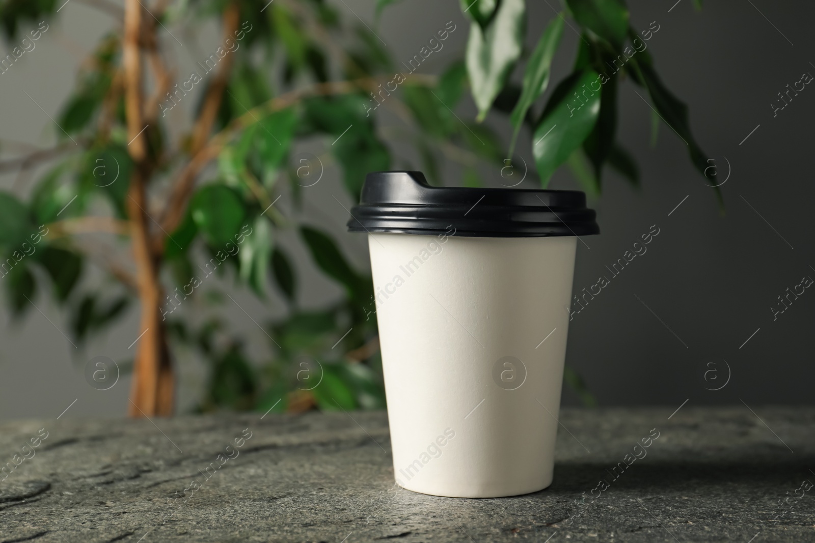 Paper cup on grey textured table indoors, closeup. Mockup for design Photo of Paper cup on grey textured table indoors, closeup. Mockup for design