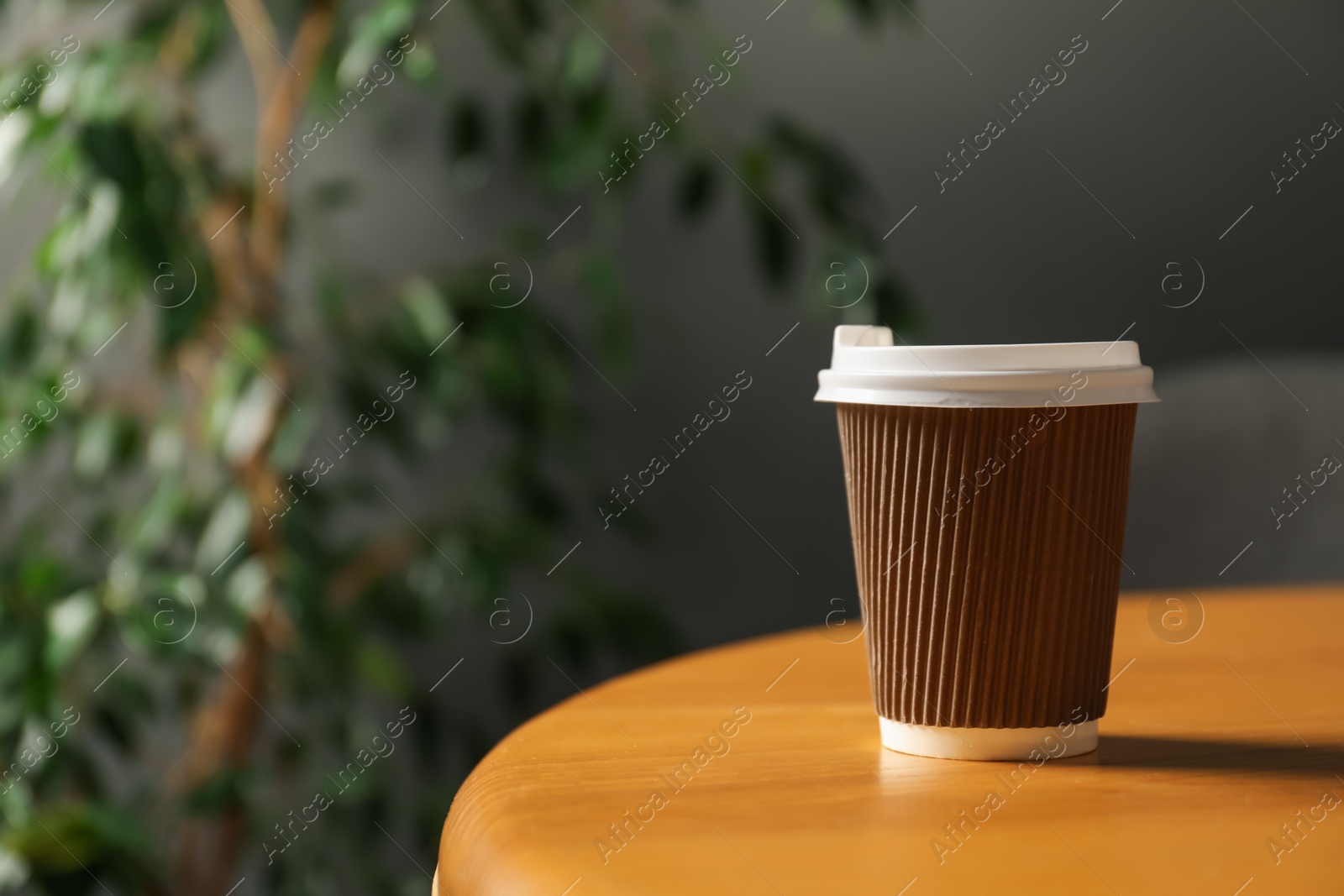 Paper cup on wooden table indoors, closeup. Mockup for design Photo of Paper cup on wooden table indoors, closeup. Mockup for design