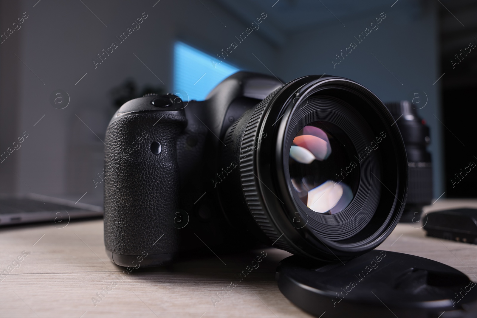 Photo of Professional photo camera on wooden desk indoors, closeup