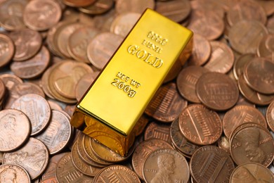 Photo of Gold bar on coins as background, closeup