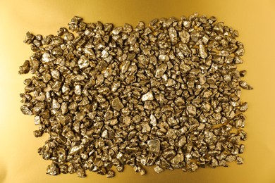 Photo of Gold nuggets on shiny background, top view