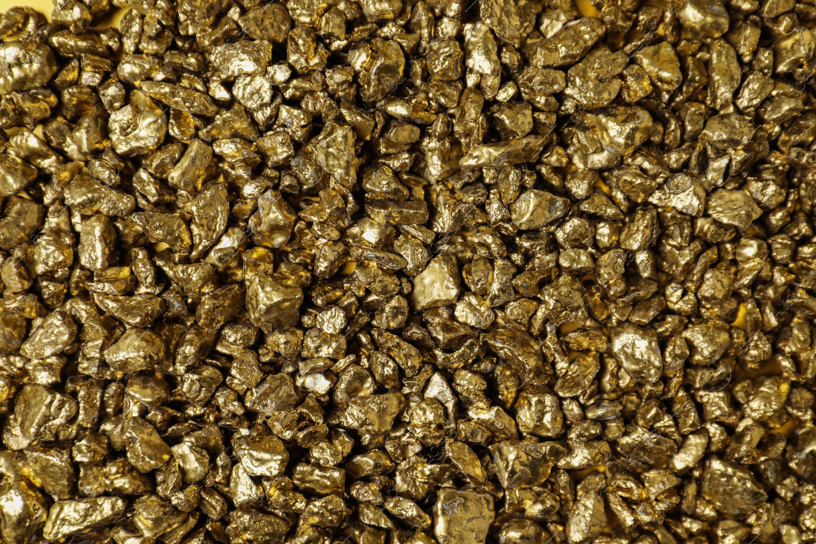 Photo of Shiny gold nuggets as background, top view