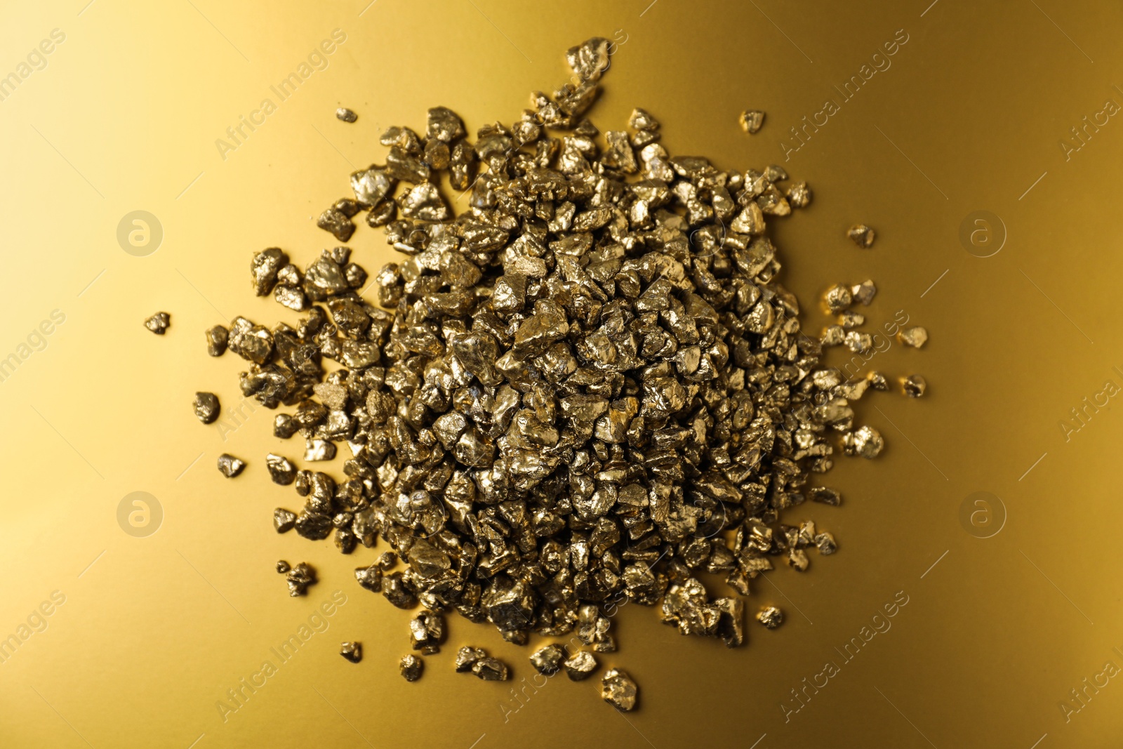 Photo of Gold nuggets on shiny background, top view