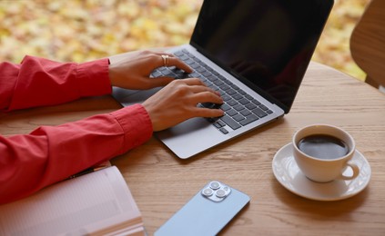 Photo of Woman working on laptop at table in cafe, closeup