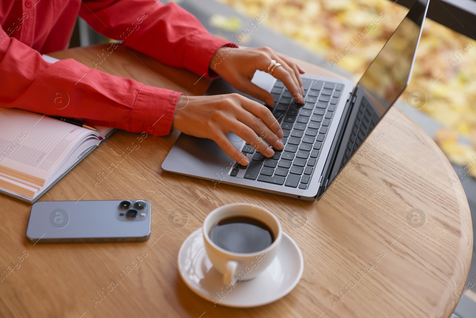 Photo of Woman working on laptop at table in cafe, closeup