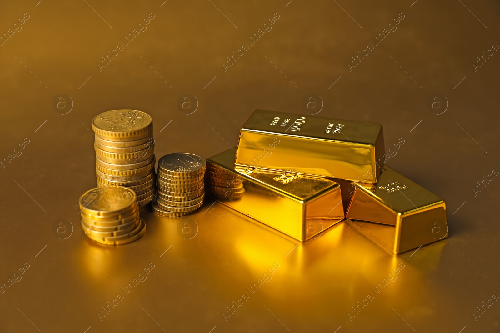 Photo of Gold bars and coins on shiny background