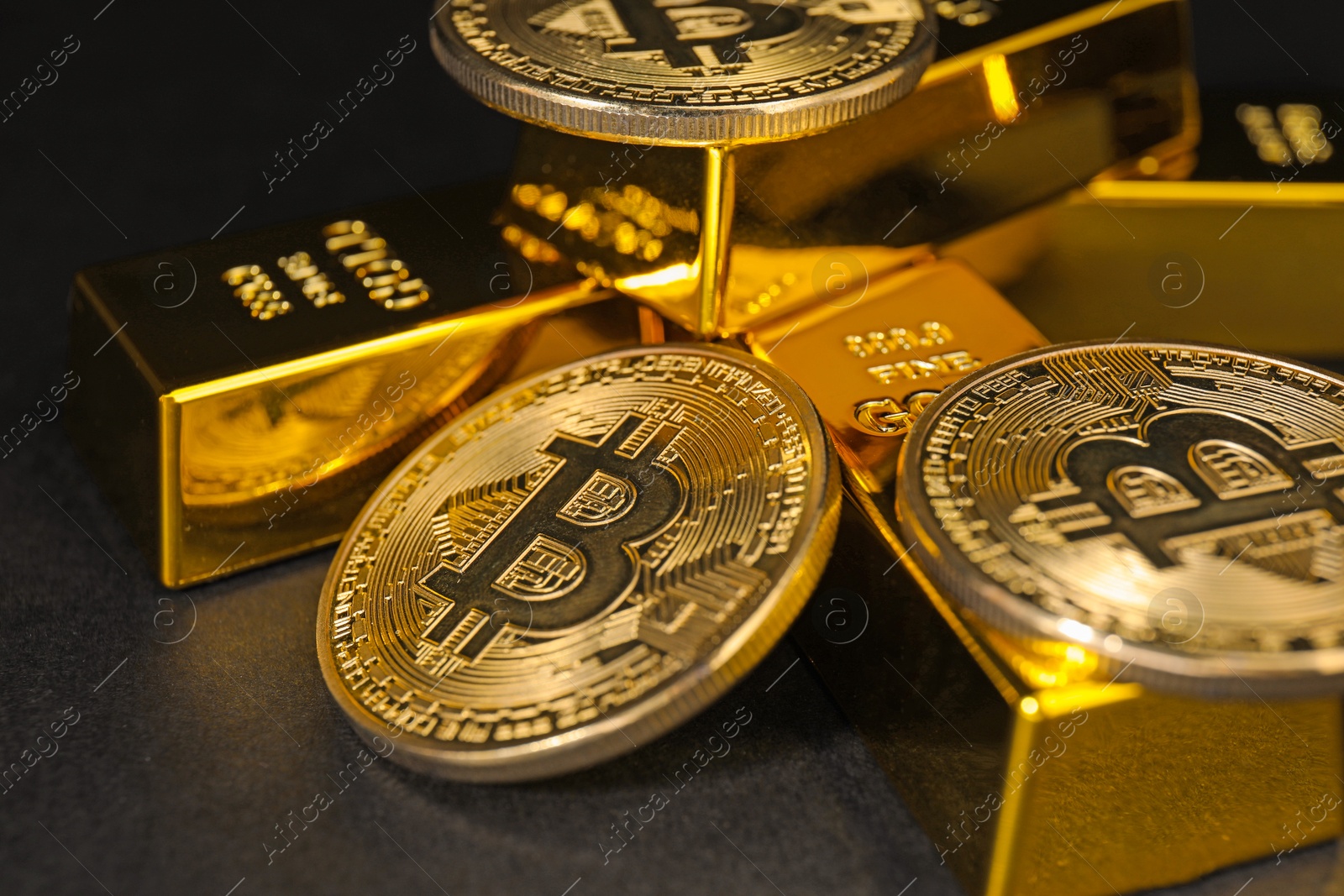 Photo of Gold bars and coins on black table, closeup