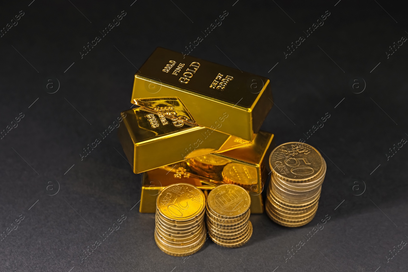 Photo of Gold bars and coins on black table, closeup