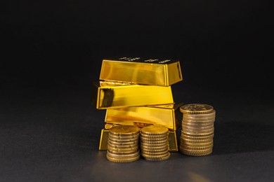 Photo of Gold bars and coins on black table