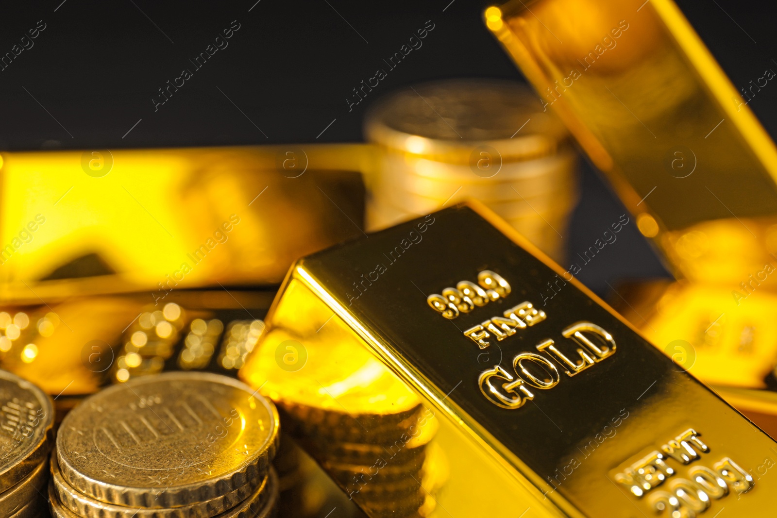 Photo of Gold bars and coins on black background, closeup