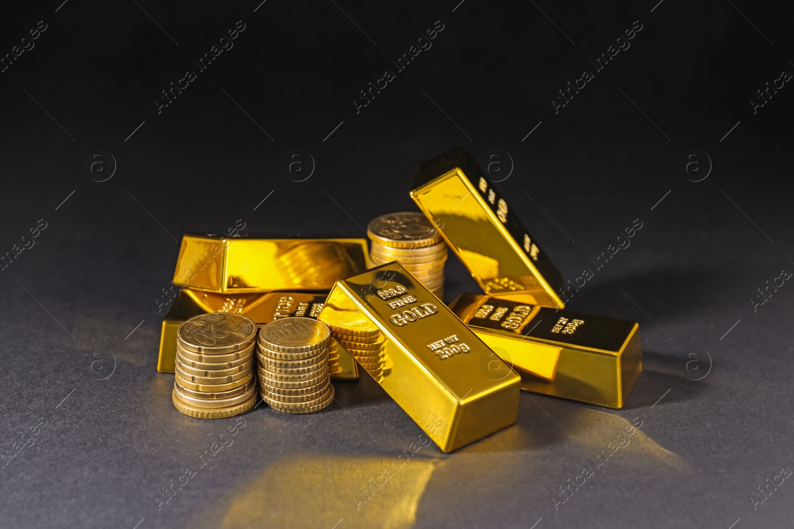 Photo of Gold bars and coins on black table