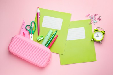 Photo of Copybooks and other school stationery on pink background, flat lay