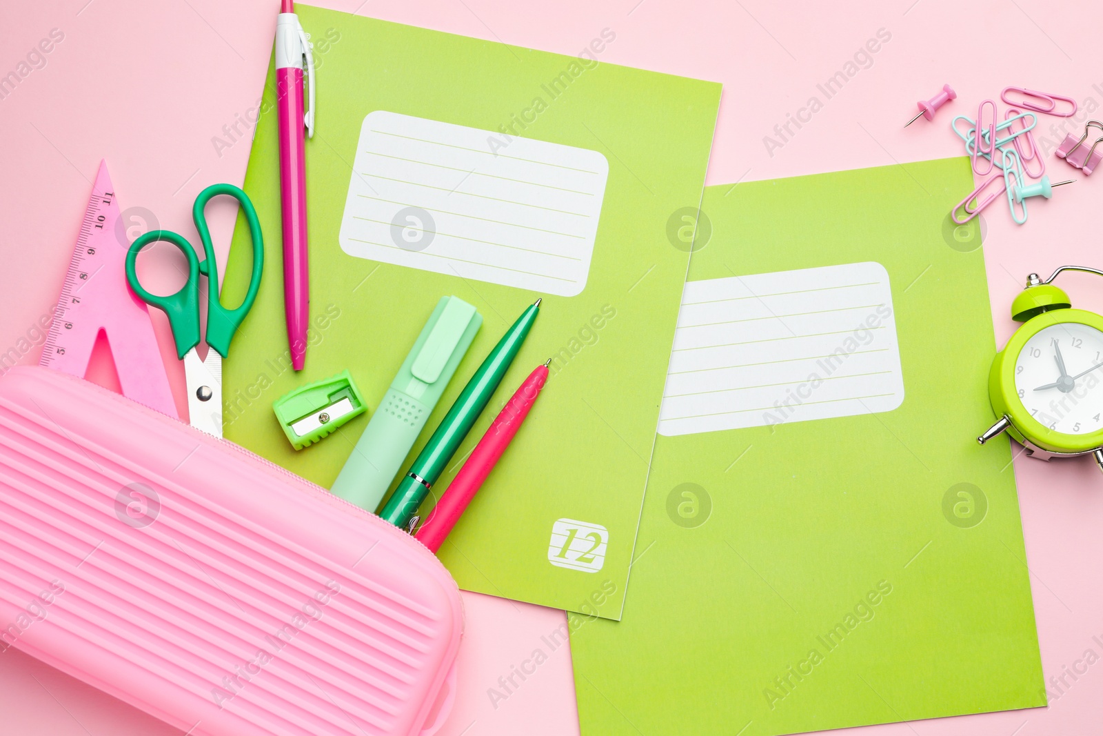 Photo of Copybooks and other school stationery on pink background, flat lay