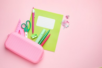 Photo of Copybook and other school stationery on pink background, flat lay. Space for text