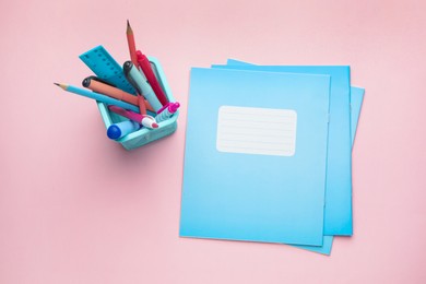 Photo of Copybooks and other school stationery on pink background, flat lay