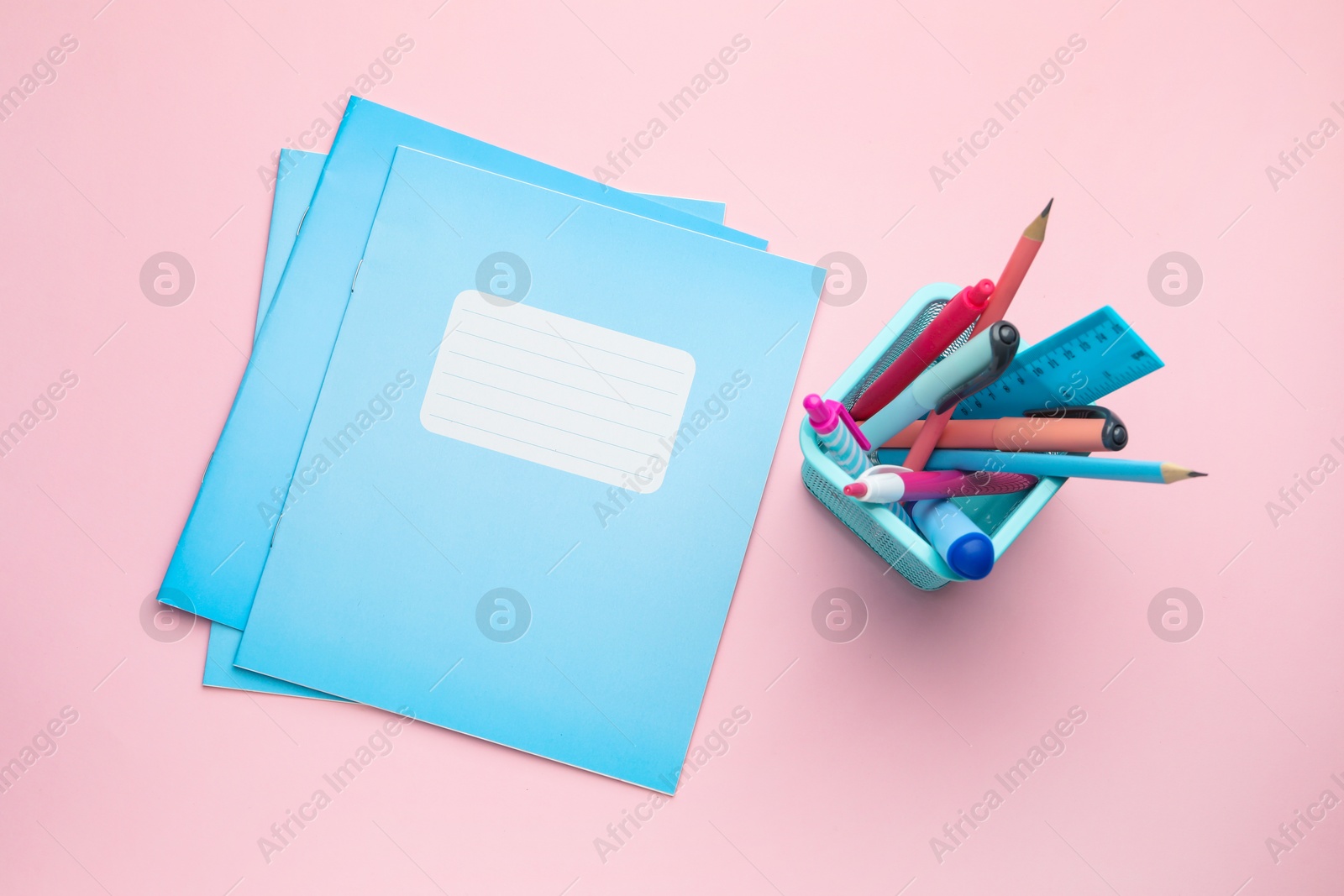 Photo of Copybooks and other school stationery on pink background, flat lay