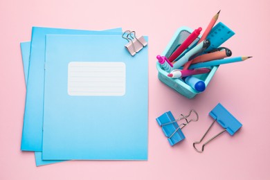 Photo of Copybooks and other school stationery on pink background, flat lay