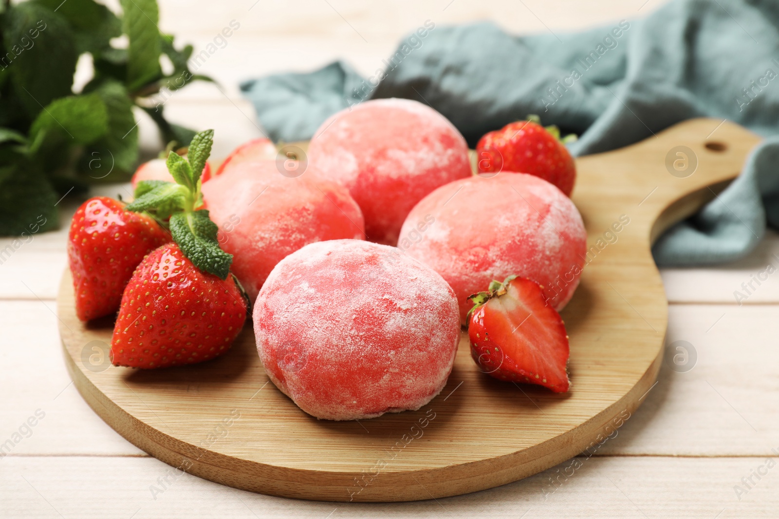 Photo of Delicious mochi, strawberries and mint on wooden table, closeup