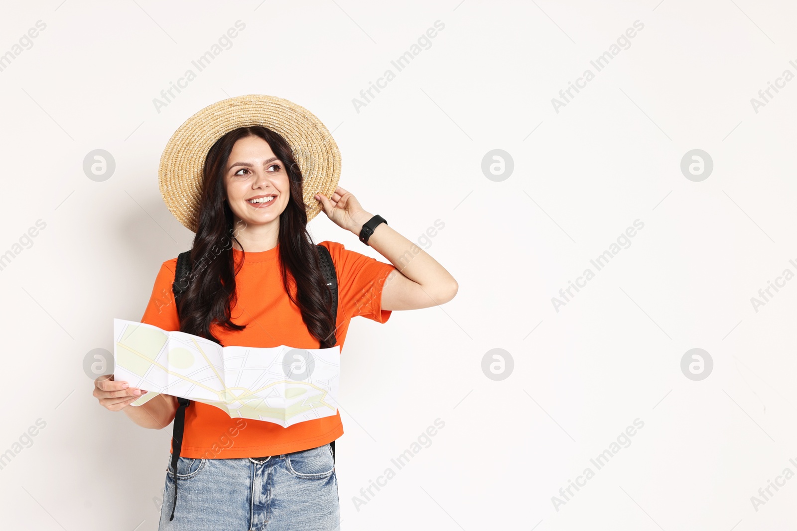 Photo of Young tourist in hat with map on white background, space for text