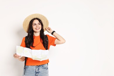 Photo of Young tourist in hat with map on white background, space for text