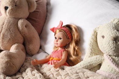 Beautiful doll, teddy bear and toy bunny in bed