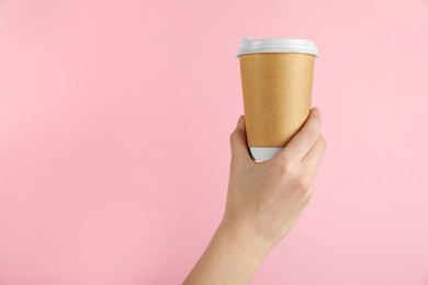 Photo of Woman holding paper cup on pink background, closeup. Mockup for design