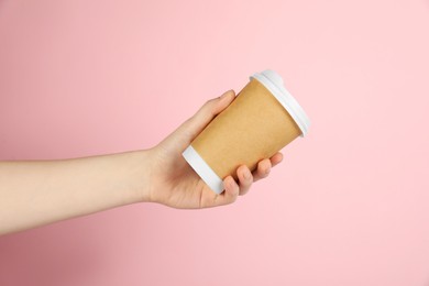 Photo of Woman holding paper cup on pink background, closeup. Mockup for design