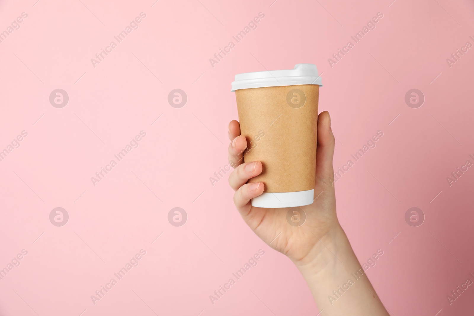 Photo of Woman holding paper cup on pink background, closeup. Mockup for design