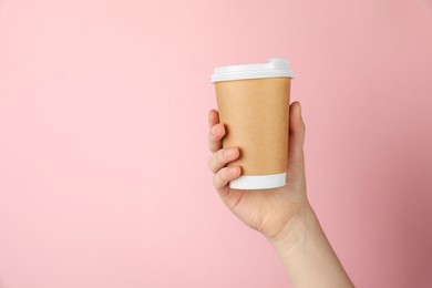 Photo of Woman holding paper cup on pink background, closeup. Mockup for design
