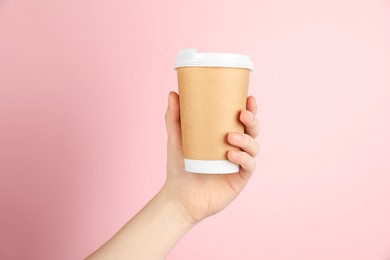 Photo of Woman holding paper cup on pink background, closeup. Mockup for design