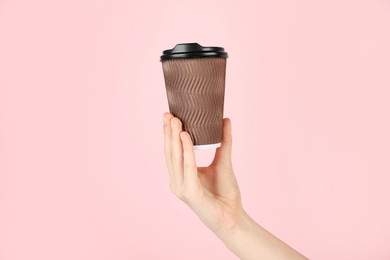 Photo of Woman holding paper cup on pink background, closeup. Mockup for design