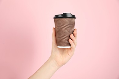 Photo of Woman holding paper cup on pink background, closeup. Mockup for design