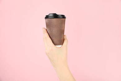 Photo of Woman holding paper cup on pink background, closeup. Mockup for design