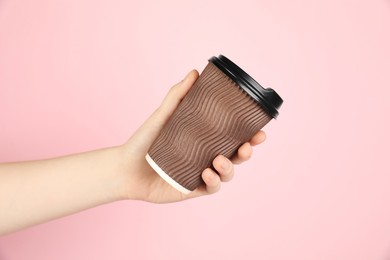 Photo of Woman holding paper cup on pink background, closeup. Mockup for design