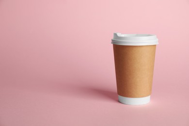 Photo of One paper cup on pink background. Mockup for design