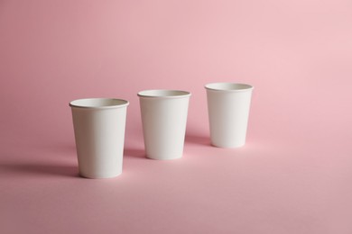 Photo of Paper cups on pink background. Mockup for design