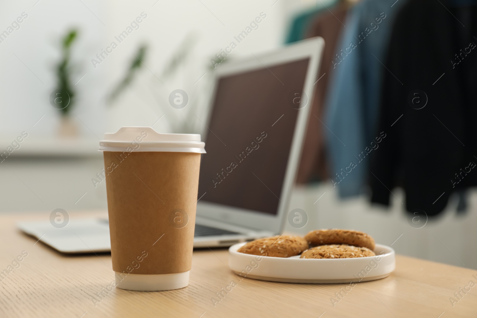 Paper cup, plate with cookies and laptop on wooden table indoors, closeup. Mockup for design Photo of Paper cup, plate with cookies and laptop on wooden table indoors, closeup. Mockup for design