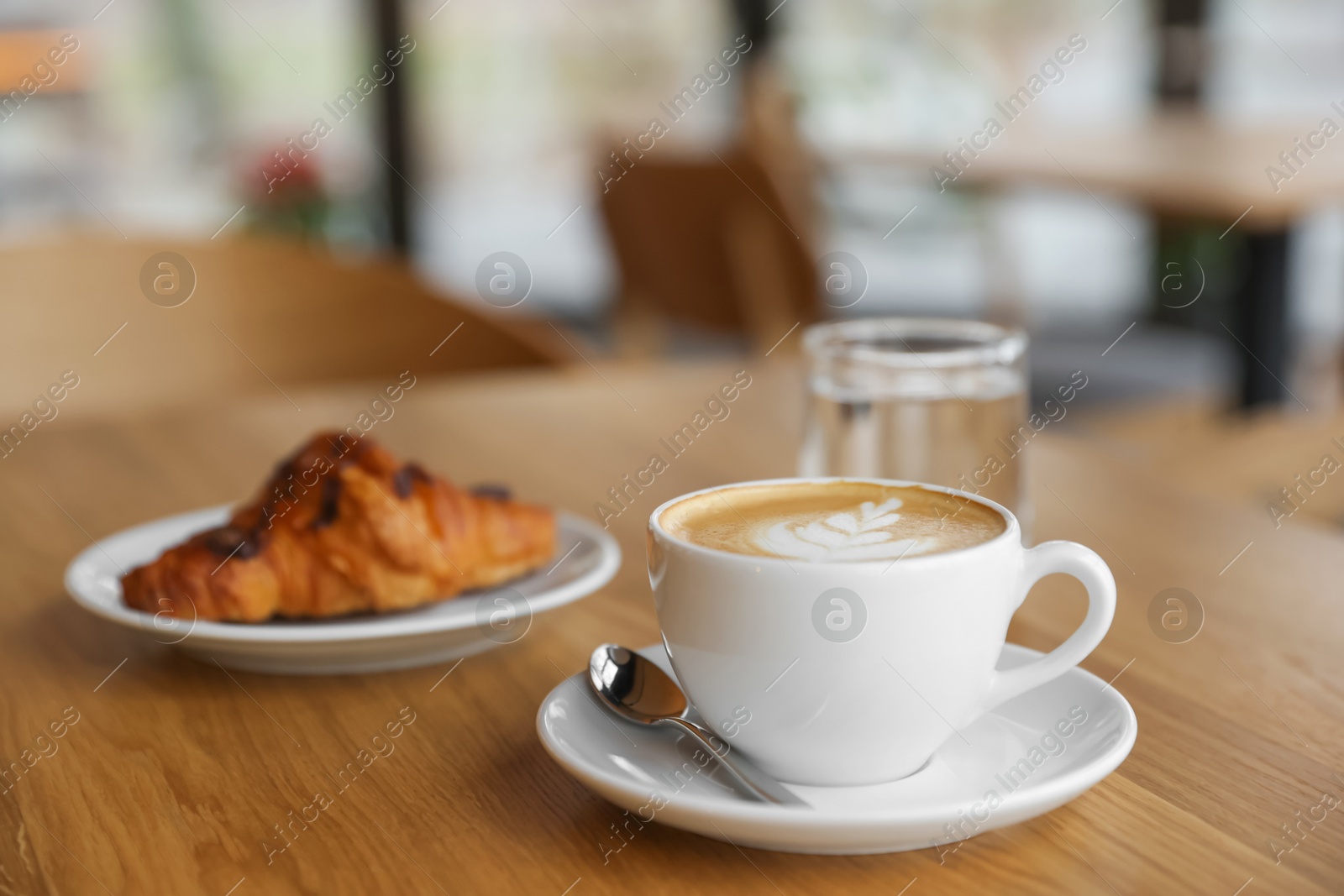 Photo of Delicious breakfast served on wooden table in cafe, closeup