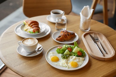 Photo of Delicious breakfast served on wooden table in cafe