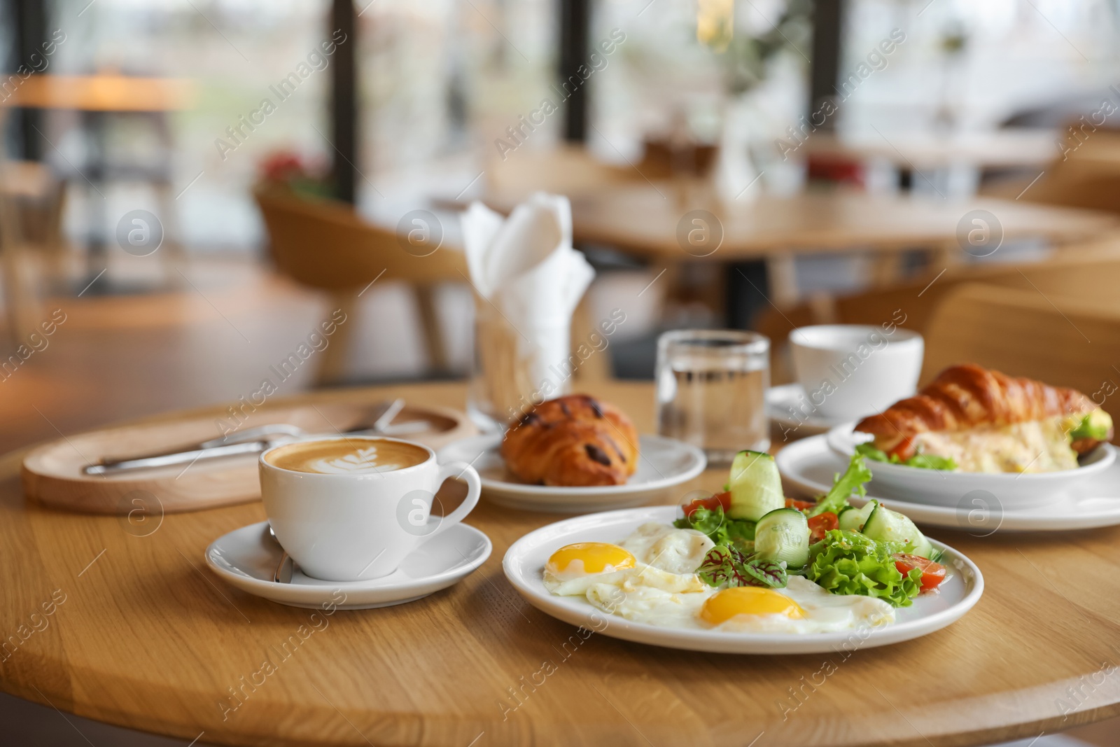 Photo of Delicious breakfast served on wooden table in cafe