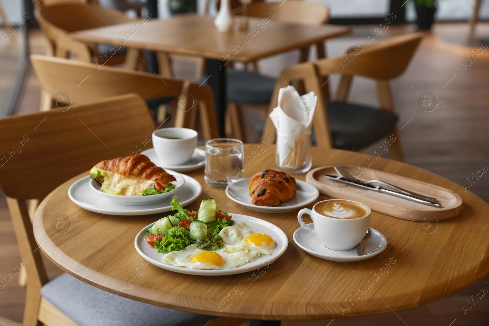 Photo of Delicious breakfast served on wooden table in cafe