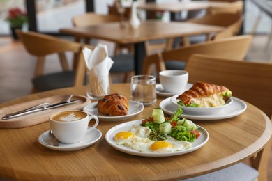 Photo of Delicious breakfast served on wooden table in cafe