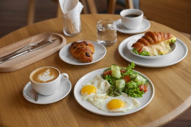 Photo of Delicious breakfast served on wooden table in cafe