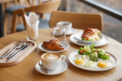 Photo of Delicious breakfast served on wooden table in cafe