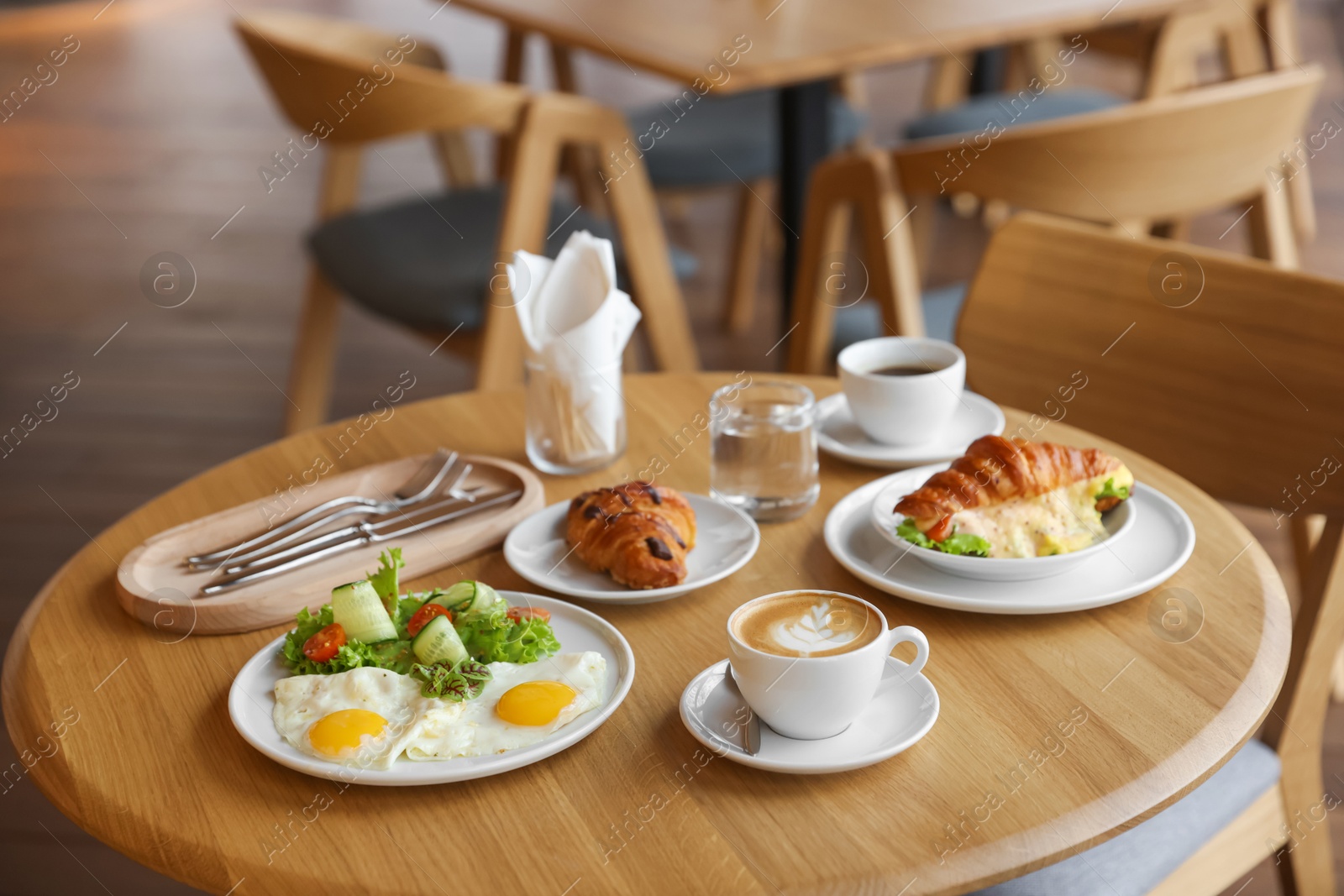 Photo of Delicious breakfast served on wooden table in cafe