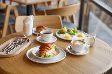 Photo of Delicious breakfast served on wooden table in cafe