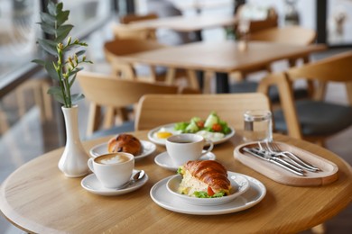 Photo of Delicious breakfast served on wooden table in cafe