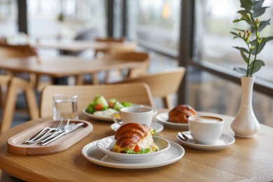 Photo of Delicious breakfast served on wooden table in cafe