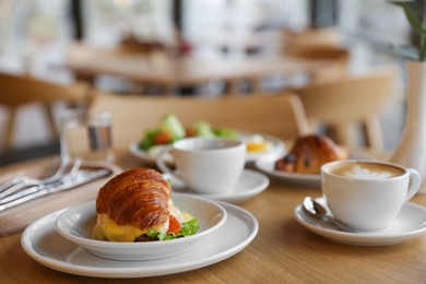 Photo of Delicious breakfast served on wooden table in cafe