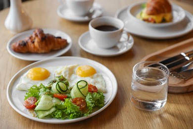 Photo of Delicious breakfast served on wooden table in cafe, closeup